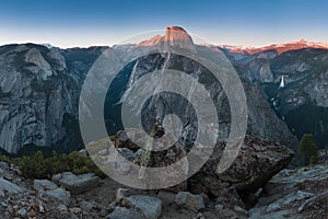 Half Dome and Yosemite Valley in Yosemite National Park during colorful sunset with trees and rocks. California, USA