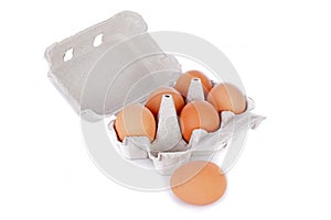 Half dozen brown chicken eggs in box isolated