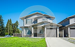 Half duplex residential building with concrete drive way and green lawn in front