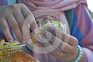 half eaten beef burger on hand