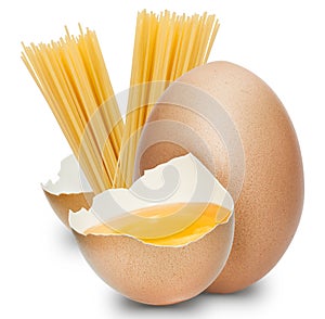 A half egg with yolk with a whole egg and bunch of spaghetti pasta on white background.