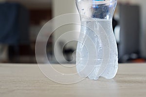 Half empty bottle of fresh water with drops