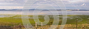 Half empty Lake George between farmland and a wind farm