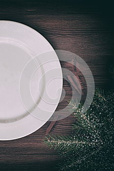 Half of an empty white plate on brown wooden surface