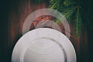 Half of an empty white plate on brown wooden surface