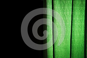 Exposed green curtain on a black background