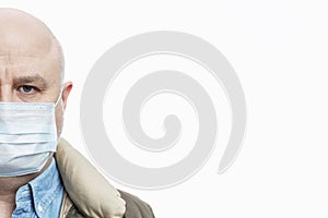 Half face of a bald adult man in a medical mask on a white background. Close-up. Precautions quarantined for the period of the