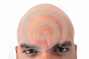 Half face of bald man in white background. Closeup of the eyes.