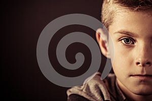 Half Face of a Boy Against Brown with Copy Space