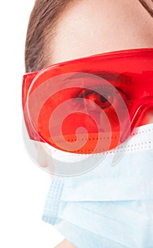 Half face of dentist woman wearing mask and protective glasses