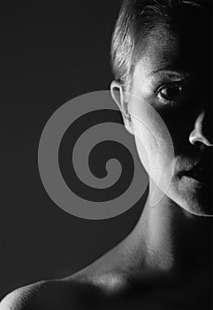 Half of the face of girl in the dark