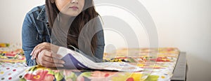 Half face portrait of Indian Bengali beautiful and cute brunette girl in a casual blue jeans shirt is reading newspaper