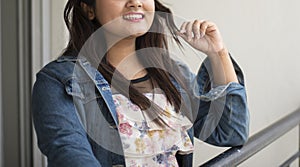 Half face portrait of an Indian Bengali beautiful and cute brunette girl in a casual blue jeans shirt and white top is standing