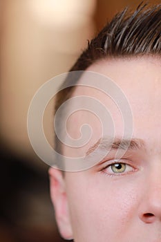 half face portrait of serious concentrated confident handsome young attractive man with fashionable fresh haircut in a