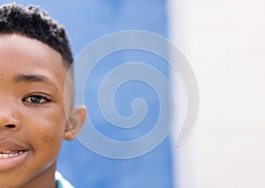Half face portrait of smiling african american boy in elementary school playground, copy space photo