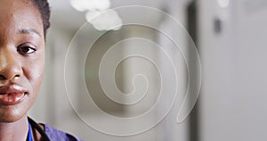 Half face video portrait of smiling african american female doctor in corridor, with copy space