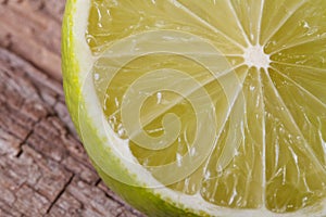 Half of fresh juicy lime on background wooden table