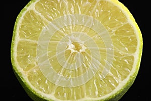 Half of fresh lime on black background, closeup