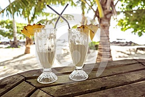 Half full glasses of tropical pina colada cocktail drink with pi photo