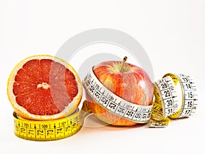 Half grapefruit and apple with tape measure