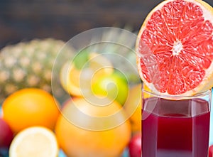 Half of grapefruit on glass with fresh juice