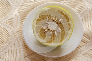 Half Of A Grapefruit In A Small White Plate