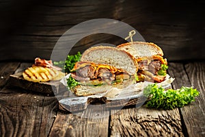 Half a hamburgers with grilled beef meat, vegetables, sauce on rustic wooden background. fast food and junk food concept