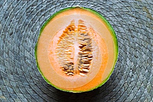 Half of Hami Melon Fruit on Green Straw Mat Background Surface