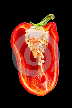 Half a juicy red bell pepper on black background