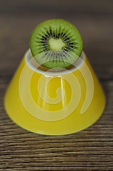 Half a kiwi on a yellow plate