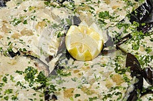 Half of lemon on aubergines, filled with mayonnaise and parsley