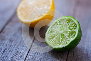 Half a lemon and lime on wooden background