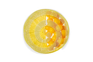 Half of lemon slice and yellow dragees with vitamins in place of the second half of lemon