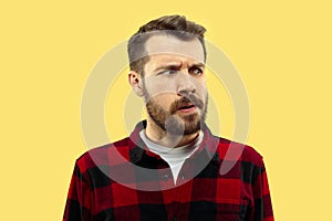 Half-length close up portrait of young man on yellow background.