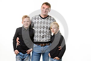 Half-length portrait of a father and two sons in casual clothes, isolated on a white background