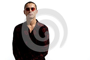 Half length portrait of young confident and succesful male enterpreneur in black shirt and red sunglasses, with short