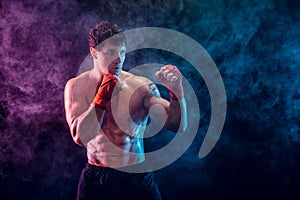 Half length of shirtless boxer fighter who preparing for fight on smoke background. Sport concept