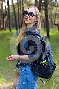 Half-length vertical portrait of a cheerful blonde on nature background