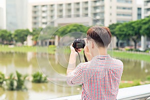 Half length of young asian man outdoor in the city taking pictur