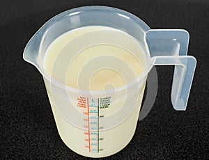 Half a liter of white milk in a transparent jug photo