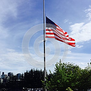 Half Mast American Flag in Bright Blue Sky