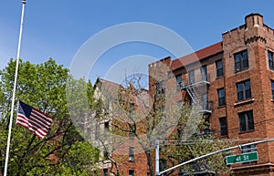 Half Mast American Flag and a Row of Old Brick Residential Buildings in Sunnyside Queens New York