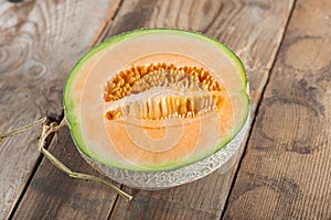 Half of melon on wood table.