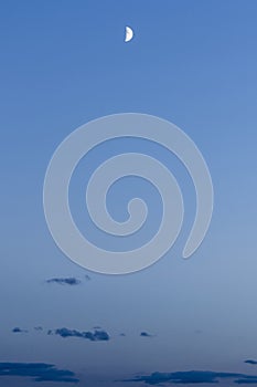 Half moon against the background of the night blue sky with dark clouds, abstract background