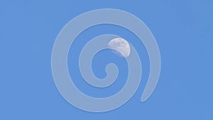 Half moon on blue sky, zoom in video, close up view