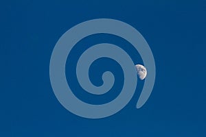 The half moon in the sky blue background.
