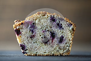 Half muffin with blueberries and walnuts on wooden table, closeup. Sweet pastries on the board. Fresh cupcakes for breakfast