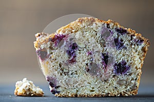 Half muffin with blueberries and walnuts on wooden table, closeup. Sweet pastries on the board. Fresh cupcakes for breakfast