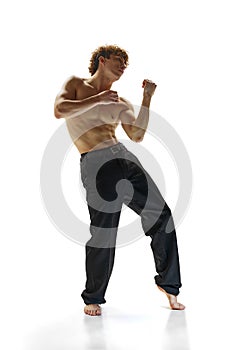 Half-naked, athletic young and stylish modern ballet dancer posing in motion against white studio background. Movement.