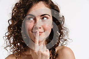 Half-naked curly woman smiling and showing silence gesture
